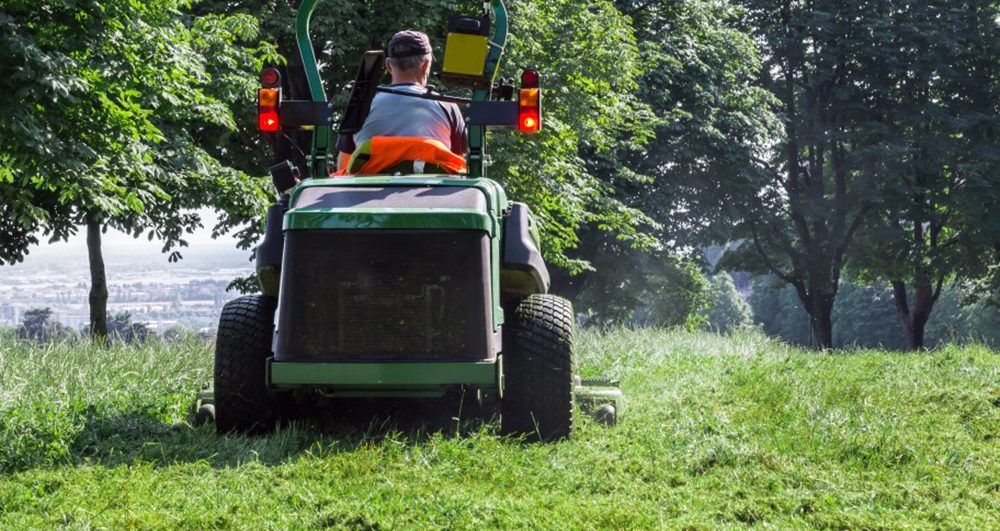male-using-lawn-mower-and-cutting-grass-around-him-a-green-landscape_t20_EnX9WY